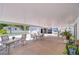 Expansive covered patio area with multiple seating arrangements, a custom mural, and garage access at 6612 N Orleans Ave, Tampa, FL 33604