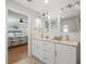 Modern bathroom with dual sink vanity and mirrors and an attached bedroom at 75 Lido Dr, St Pete Beach, FL 33706