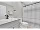 Bright bathroom features a modern vanity with sleek black fixtures, toilet, and tub with decorative shower curtain at 7721 Twin Leaf Ter, Parrish, FL 34219