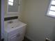 Half bathroom features white vanity with accent backsplash tile, and framed mirror at 8255 Richmond St, Gibsonton, FL 33534