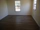 An empty bedroom features wood-look flooring and two windows for natural light at 8255 Richmond St, Gibsonton, FL 33534