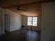 Open living room area with wood beam ceiling, lots of natural light, and wood-look flooring at 8255 Richmond St, Gibsonton, FL 33534