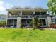 Backyard view of the exterior of the house, with multi-level screened patios and a lush lawn at 8304 Aquila St, Port Richey, FL 34668