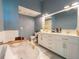 Bathroom with modern blue walls, a soaking tub, and a double sink vanity at 8304 Aquila St, Port Richey, FL 34668