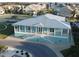 Charming coastal-style clubhouse with a covered porch, white railings, and a well-manicured lawn at 8304 Aquila St, Port Richey, FL 34668