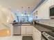 Bright kitchen featuring white cabinets, stainless steel appliances, and modern lighting fixtures at 8304 Aquila St, Port Richey, FL 34668