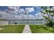 Beautiful backyard view of waterfront with pavers and green grass under cloudy skies at 8635 Boca Ciega Dr, St Pete Beach, FL 33706