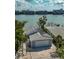 Aerial view of rear exterior featuring a gray roof with solar panels, garage, and paved driveway at 8635 Boca Ciega Dr, St Pete Beach, FL 33706
