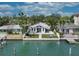 Charming waterfront home featuring a manicured lawn, waterfront access, and an inviting exterior at 8635 Boca Ciega Dr, St Pete Beach, FL 33706