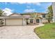 Two story home with tile roof and stone driveway, landscaped yard and two car garage at 892 Harbor Is, Clearwater Beach, FL 33767