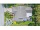 Aerial view of the house showing the roof, screened patio, and surrounding lush landscaping at 9112 Calle Alta, New Port Richey, FL 34655