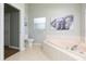 Bright bathroom featuring a bathtub, toilet, and colorful elephant artwork at 9112 Calle Alta, New Port Richey, FL 34655