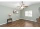 Simple bedroom featuring wood floors, ceiling fan, and natural light at 9112 Calle Alta, New Port Richey, FL 34655