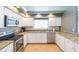 Modern kitchen with stainless steel appliances, granite countertops, and white cabinetry at 9112 Calle Alta, New Port Richey, FL 34655