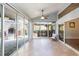 Enclosed sunroom with tiled floor and access to outdoor kitchen and fireplace at 9112 Calle Alta, New Port Richey, FL 34655