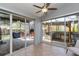 Enclosed sunroom with tiled flooring, leads to outdoor kitchen and fireplace at 9112 Calle Alta, New Port Richey, FL 34655