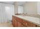 Bright bathroom featuring granite counters, cherry cabinets, and a shower with white curtains at 923 Lumsden Reserve Dr, Brandon, FL 33511
