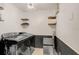 Modern laundry room featuring a front-load washer and dryer and storage shelving at 923 Lumsden Reserve Dr, Brandon, FL 33511