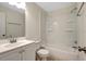 Bright bathroom with tub-shower, white fixtures, and a vanity with chrome fixtures at 9403 N 13Th St, Tampa, FL 33612