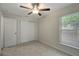 Bright bedroom with ceiling fan, neutral carpet, and window overlooking the outdoors at 9403 N 13Th St, Tampa, FL 33612