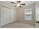 Comfortable carpeted bedroom with ceiling fan and a view to the outside at 9403 N 13Th St, Tampa, FL 33612