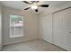 Cozy bedroom with a ceiling fan, soft carpet, closet, and natural light from the window at 9403 N 13Th St, Tampa, FL 33612
