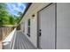 Front door with a charming dark fixture and gray painted ramp-entryway and a grassy view at 9403 N 13Th St, Tampa, FL 33612