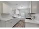 Well-lit kitchen features a window, white cabinets, quartz countertops, and wood-look floors at 9403 N 13Th St, Tampa, FL 33612