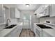 Updated kitchen with all-white cabinetry, appliances, quartz countertops, and modern light fixture at 9403 N 13Th St, Tampa, FL 33612