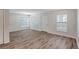 Sun-drenched living room featuring hardwood floors, multiple windows, and freshly painted walls at 9403 N 13Th St, Tampa, FL 33612