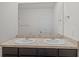 Bathroom featuring double sinks, dark wood cabinets, a full mirror, and towel racks at 10940 Trailing Vine Dr, Tampa, FL 33610