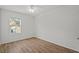 Bedroom with hardwood floors, white walls, ceiling fan, and a window offering natural light at 10940 Trailing Vine Dr, Tampa, FL 33610
