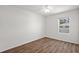 Bedroom with hardwood floors, white walls, ceiling fan, and a bright window at 10940 Trailing Vine Dr, Tampa, FL 33610