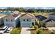Charming two-story home in a residential neighborhood, with a well-maintained lawn, and a gray two car garage door at 10940 Trailing Vine Dr, Tampa, FL 33610