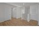 Hallway with hardwood floors and white trim leading to rooms and staircase at 10940 Trailing Vine Dr, Tampa, FL 33610