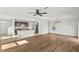 Open-concept living area with hardwood floors, neutral paint, and a ceiling fan at 10940 Trailing Vine Dr, Tampa, FL 33610