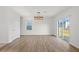 Open-concept living room featuring wood flooring, a sliding door, and ample natural light at 10940 Trailing Vine Dr, Tampa, FL 33610