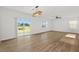 Bright living room with wood-style flooring, sliding glass doors, and contemporary lighting at 10940 Trailing Vine Dr, Tampa, FL 33610