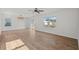 Bright living room with wood flooring, ceiling fan, and natural light from windows and sliding glass door at 10940 Trailing Vine Dr, Tampa, FL 33610