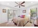 Bright bedroom featuring carpeted floors, ceiling fan, and sliding glass door to the outdoors at 1118 Captains Way, Tarpon Springs, FL 34689