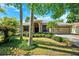 Inviting single-story home showcasing mature landscaping, a two-car garage, and a covered front porch at 1118 Captains Way, Tarpon Springs, FL 34689