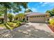 Well-maintained home displaying mature landscaping, a driveway, and a convenient two-car garage at 1118 Captains Way, Tarpon Springs, FL 34689