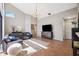 Bright living room featuring a dark leather sofa, statement chandelier, and tile flooring at 1118 Captains Way, Tarpon Springs, FL 34689