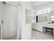 Bright bathroom with double sinks and an adjacent shower stall, set on a tile floor at 1118 Captains Way, Tarpon Springs, FL 34689