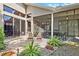Landscaped patio area featuring a paved seating area and a screened-in patio at 1118 Captains Way, Tarpon Springs, FL 34689