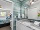 Updated bathroom with vanity and decorative wood paneling with access to bedroom at 11485 Oakhurst Rd # 312, Largo, FL 33774