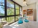 Bright breakfast nook featuring a glass table set, built-in shelving, and sun-filled views from large windows at 11485 Oakhurst Rd # 312, Largo, FL 33774