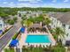 Scenic aerial view of a resort-style pool area surrounded by residential buildings, palm trees, and outdoor seating at 11541 Fountainhead Dr, Tampa, FL 33626
