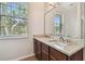 Bathroom featuring granite countertops, double sinks, and a large window at 11541 Fountainhead Dr, Tampa, FL 33626