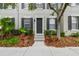Charming exterior view of townhome with gray siding, black shutters, and lush landscaping at 11541 Fountainhead Dr, Tampa, FL 33626
